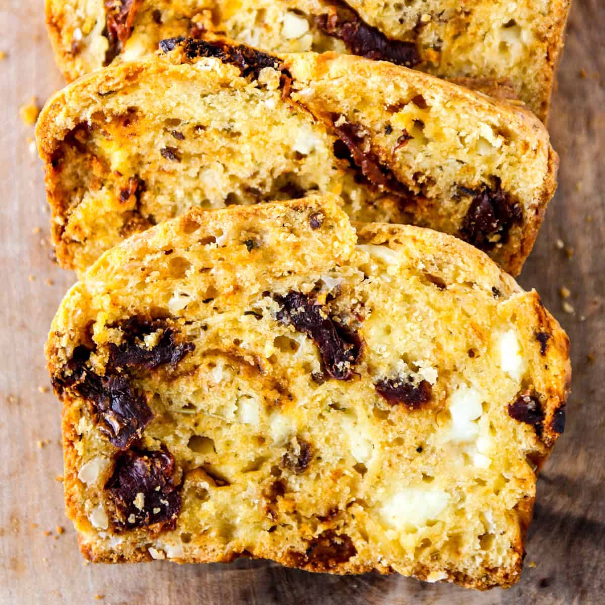 Sliced sun-dried tomato bread on a cutting board.