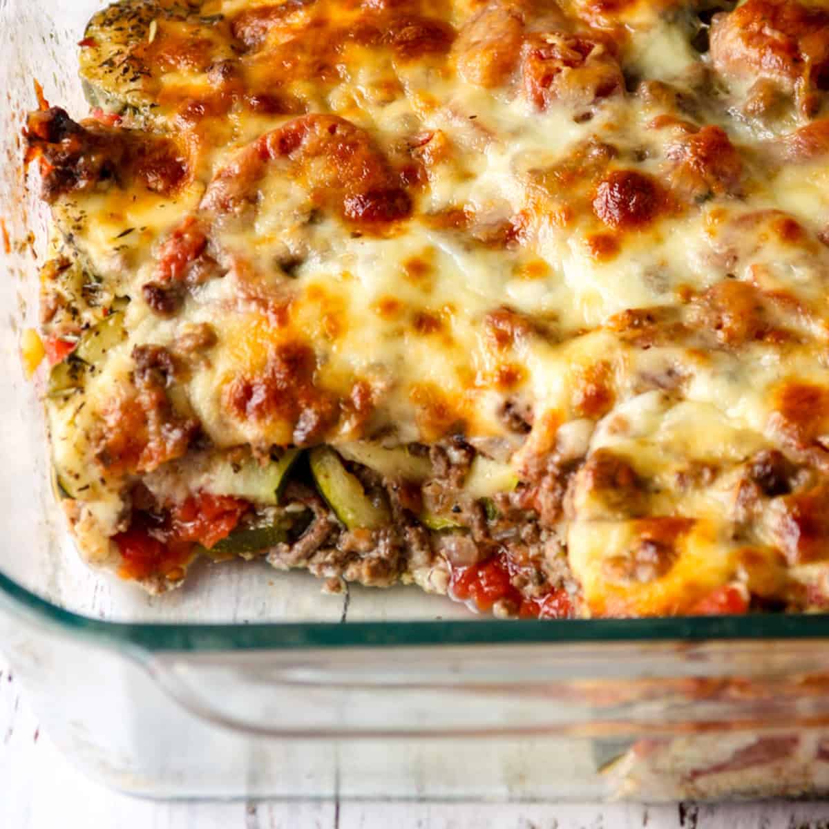 Ground beef zucchini casserole in a glass baking dish.