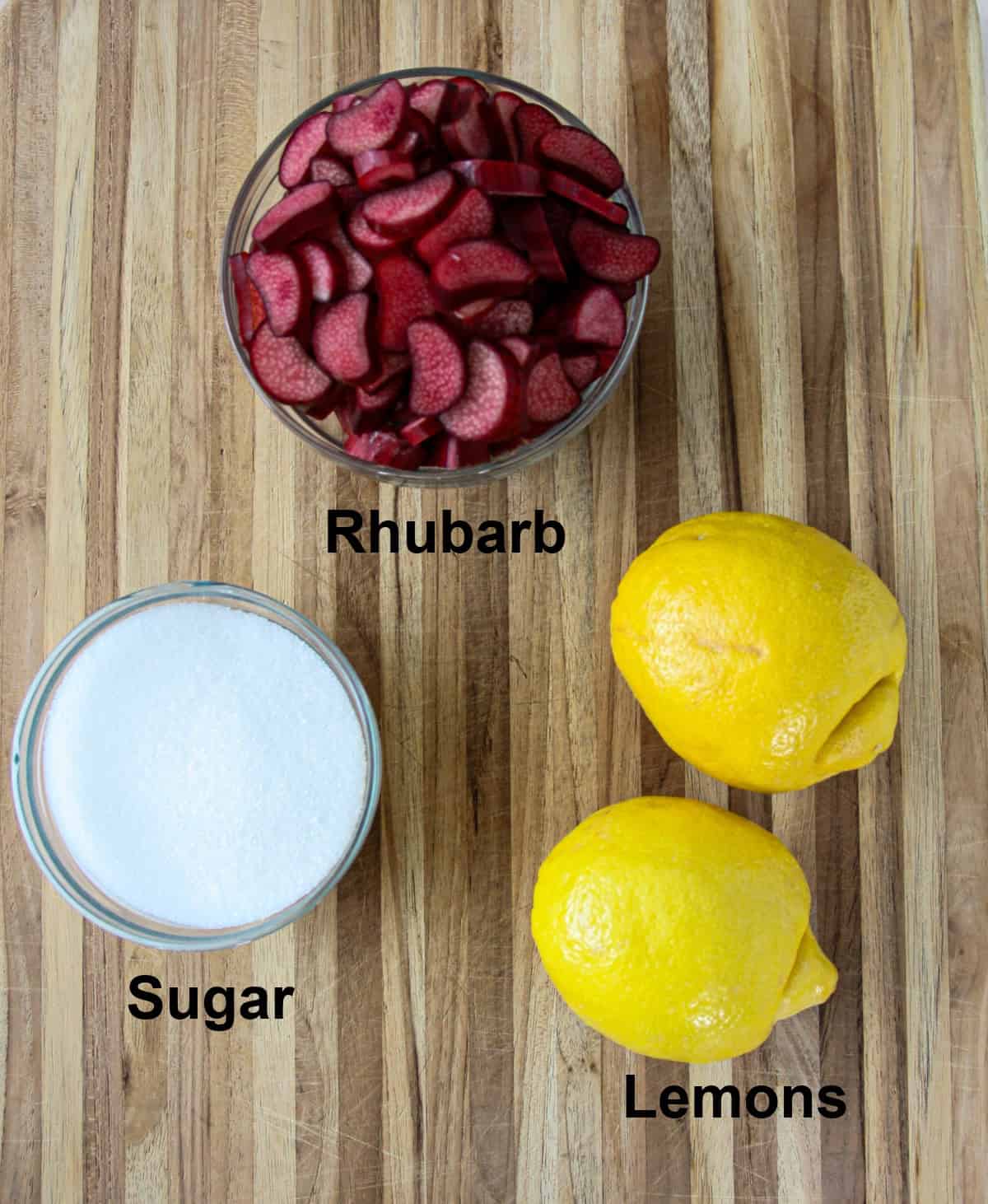 The ingredients for making rhubarb lemonade on a wooden board.