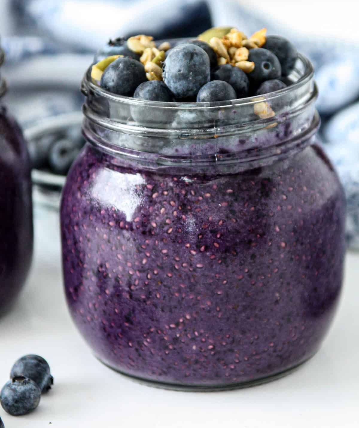 Blueberry chia pudding in a glass jar, topped with fresh blueberries and granola.