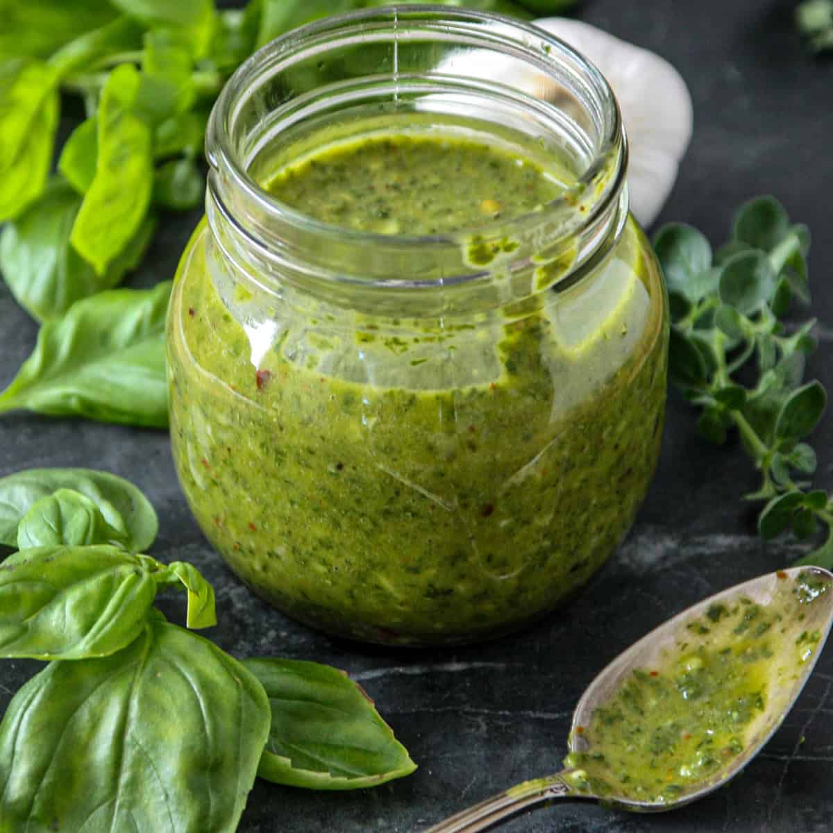 Basil chimichurri sauce in a glass jar.